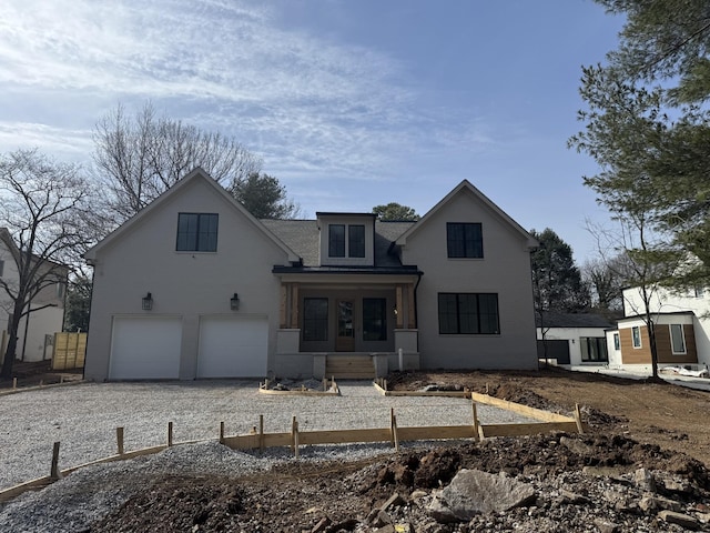 view of front of property with gravel driveway and a garage