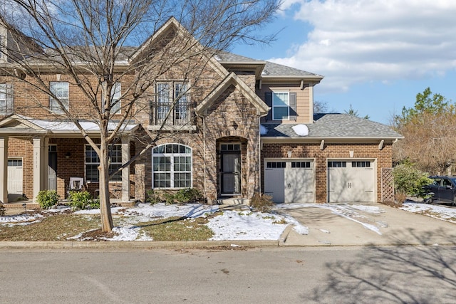 view of front of house featuring brick siding, concrete driveway, an attached garage, a balcony, and stone siding