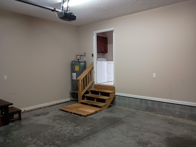 garage featuring water heater, separate washer and dryer, baseboards, and a garage door opener