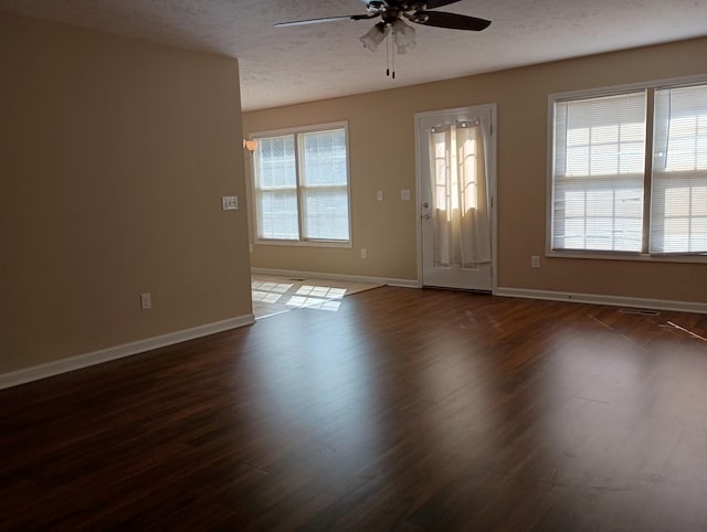 foyer entrance featuring dark wood-style floors, ceiling fan, a textured ceiling, and baseboards