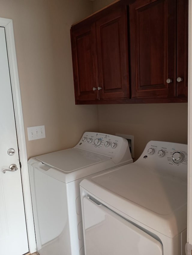 clothes washing area featuring cabinet space and washing machine and clothes dryer