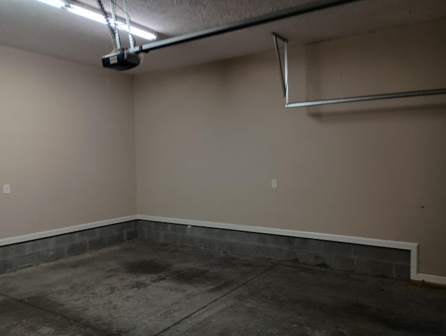 garage featuring concrete block wall and a garage door opener