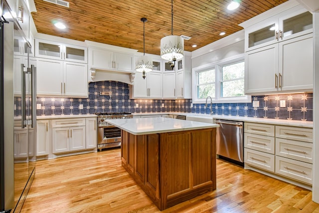 kitchen featuring high end appliances, wood ceiling, light countertops, premium range hood, and a sink