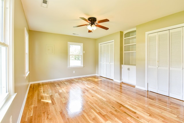 3635 Old Williamsport Rd, Williamsport, TN 38487 - unfurnished bedroom with light wood-type flooring, visible vents, baseboards, and two closets