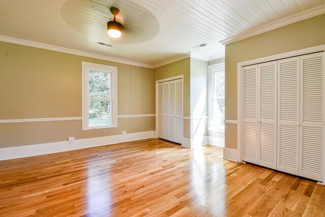 3635 Old Williamsport Rd, Williamsport, TN 38487 - unfurnished bedroom with visible vents, baseboards, light wood-type flooring, two closets, and crown molding