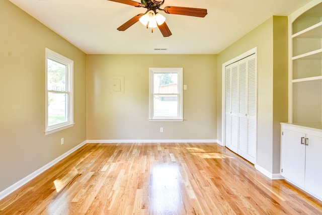 3635 Old Williamsport Rd, Williamsport, TN 38487 - unfurnished bedroom featuring light wood-style flooring, multiple windows, baseboards, and a closet