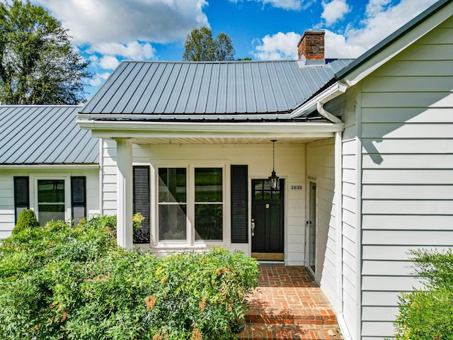 3635 Old Williamsport Rd, Williamsport, TN 38487 - view of exterior entry with a chimney and metal roof