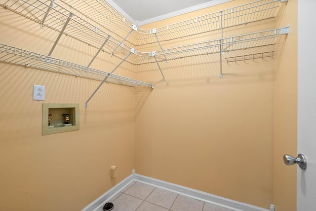 clothes washing area featuring laundry area, hookup for a washing machine, baseboards, and light tile patterned floors