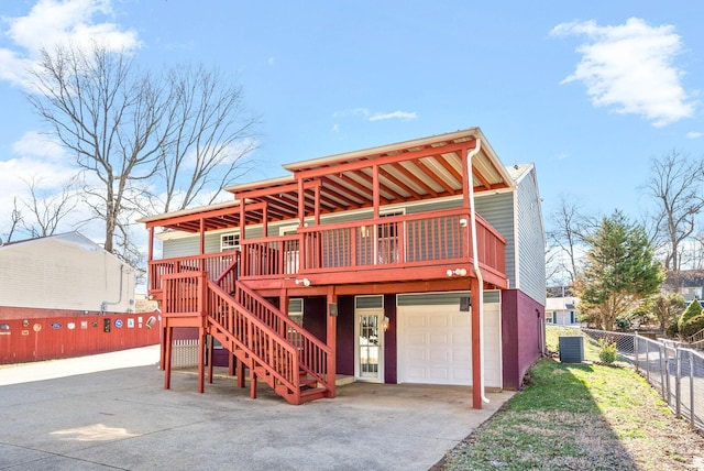 rear view of property with a garage, central AC, fence, driveway, and stairway