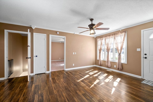 foyer entrance with crown molding, a textured ceiling, baseboards, and dark wood-style flooring