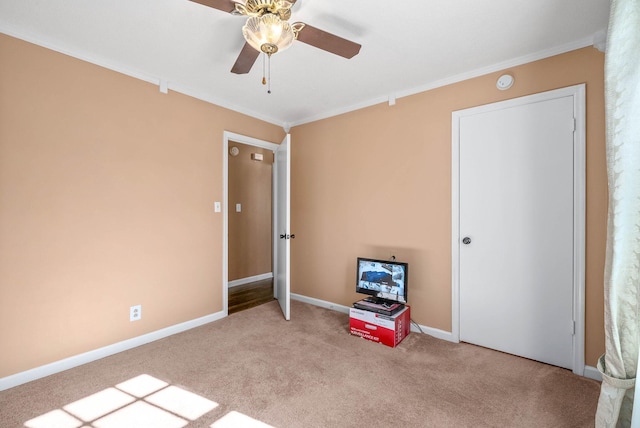 unfurnished bedroom with ornamental molding, ceiling fan, carpet floors, and baseboards