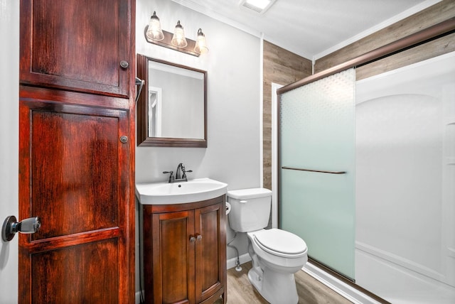 bathroom with a stall shower, visible vents, toilet, wood finished floors, and vanity