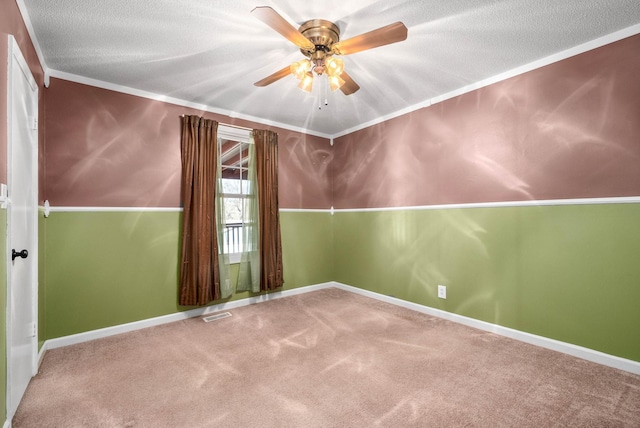 spare room featuring crown molding, visible vents, a ceiling fan, carpet flooring, and a textured ceiling