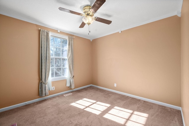 carpeted empty room with ornamental molding, visible vents, and baseboards