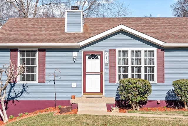 view of front of home featuring a shingled roof and a chimney