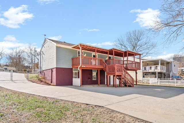 view of front of home featuring stairway, a gate, fence, and a wooden deck