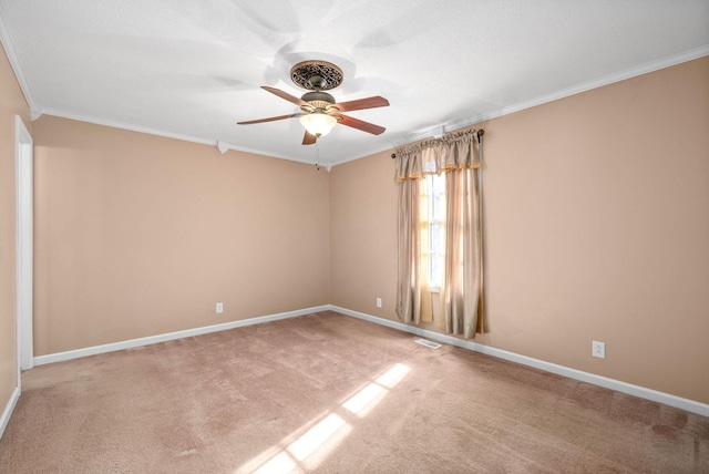 unfurnished room with carpet floors, visible vents, ornamental molding, ceiling fan, and baseboards