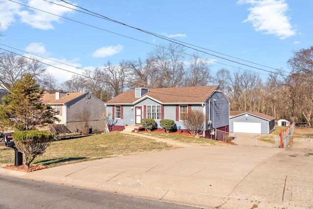 view of front of home featuring a garage, an outbuilding, fence, and a front lawn