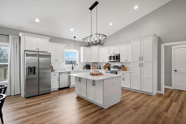 kitchen with white cabinetry, stainless steel appliances, a sink, and light countertops