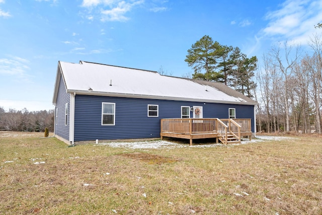 back of property featuring a deck and a lawn