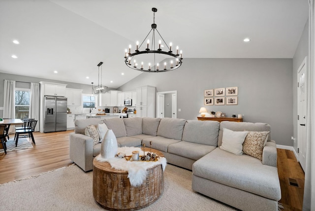 living area with an inviting chandelier, light wood-type flooring, visible vents, and recessed lighting