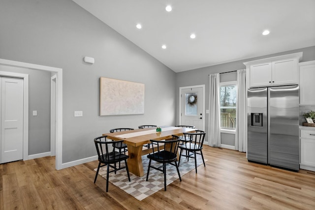 dining space featuring light wood finished floors, baseboards, high vaulted ceiling, and recessed lighting