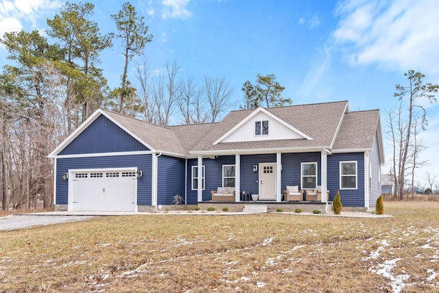 view of front facade featuring a porch, an attached garage, a shingled roof, driveway, and a front lawn