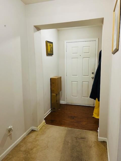 doorway with carpet flooring and baseboards