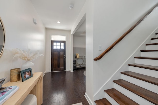 foyer entrance featuring dark wood-type flooring, baseboards, and stairs