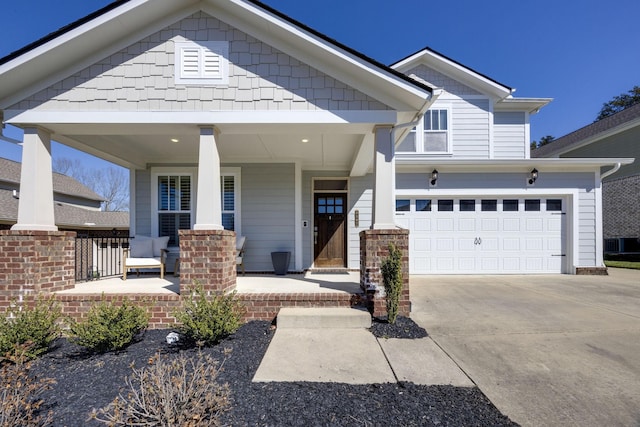 craftsman inspired home featuring a garage, a porch, and concrete driveway