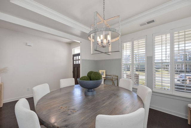 dining room with a chandelier, wood finished floors, visible vents, baseboards, and crown molding