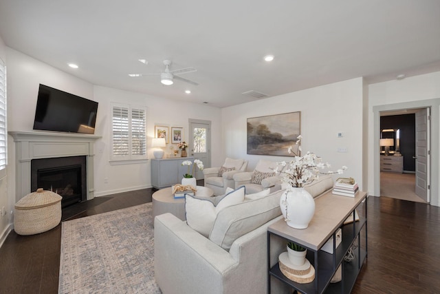 living area with recessed lighting, wood finished floors, a fireplace with flush hearth, baseboards, and a ceiling fan