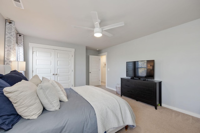 bedroom featuring a closet, visible vents, light carpet, ceiling fan, and baseboards