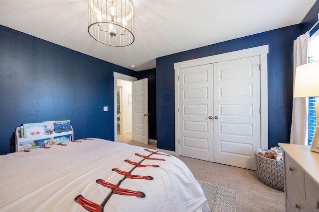 bedroom with light carpet, a chandelier, and a closet