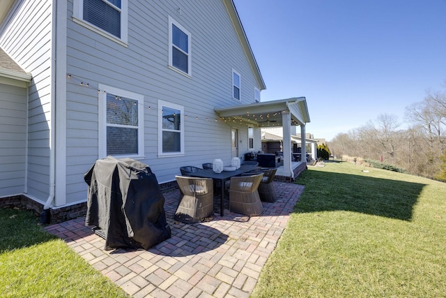 rear view of property with a lawn and a patio area