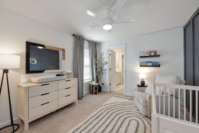 bedroom with a ceiling fan, light carpet, connected bathroom, and baseboards