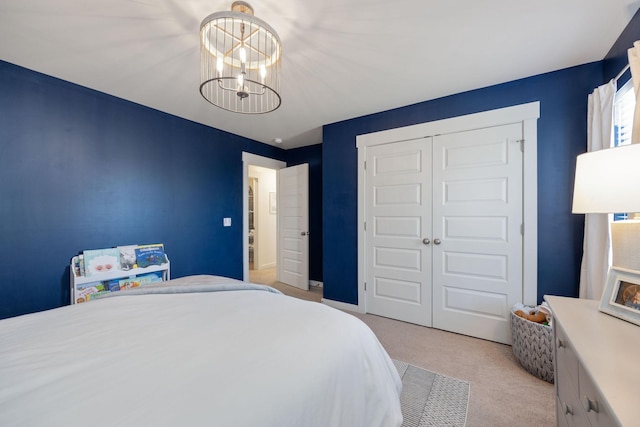 bedroom featuring carpet, a closet, and a notable chandelier