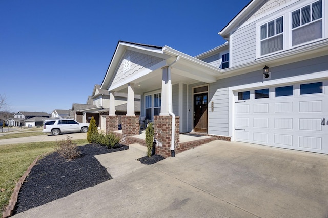 view of front of property featuring a garage, covered porch, and driveway