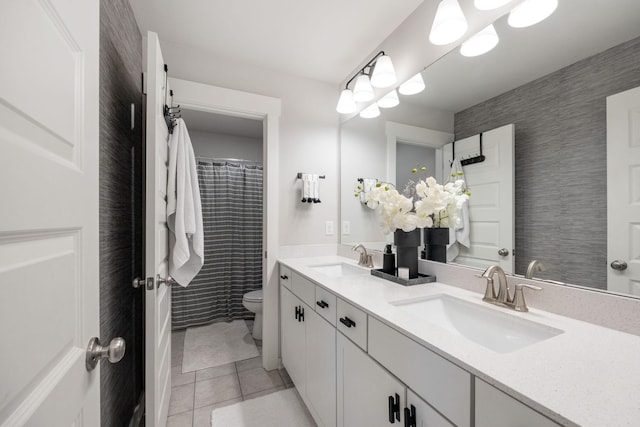 bathroom featuring tile patterned flooring, a sink, toilet, and double vanity