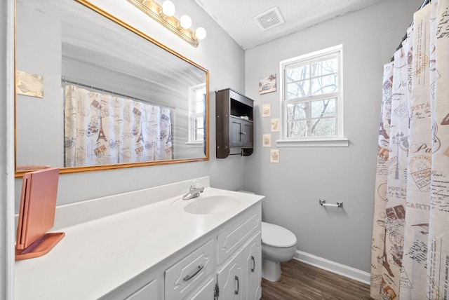 full bath featuring baseboards, visible vents, toilet, wood finished floors, and vanity