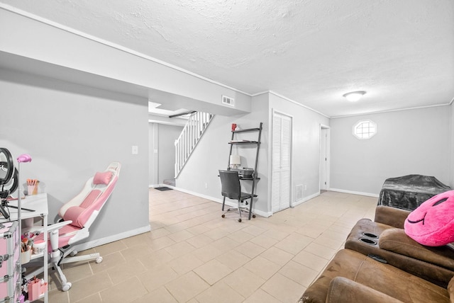 living area with baseboards, visible vents, stairway, and a textured ceiling