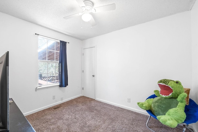 unfurnished bedroom with carpet floors, ceiling fan, baseboards, and a textured ceiling