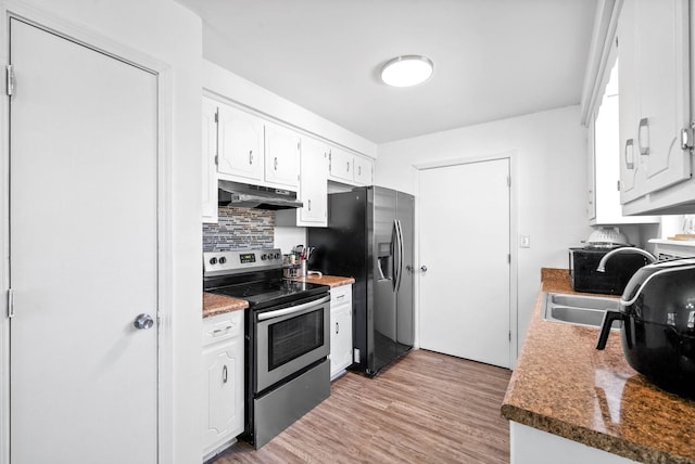 kitchen with light wood finished floors, decorative backsplash, appliances with stainless steel finishes, under cabinet range hood, and white cabinetry