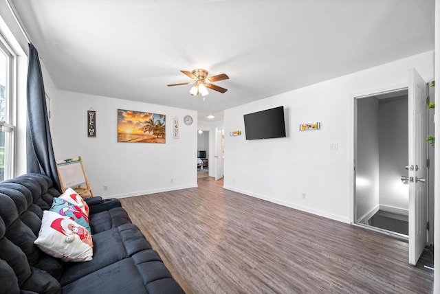 living area with ceiling fan, baseboards, and wood finished floors