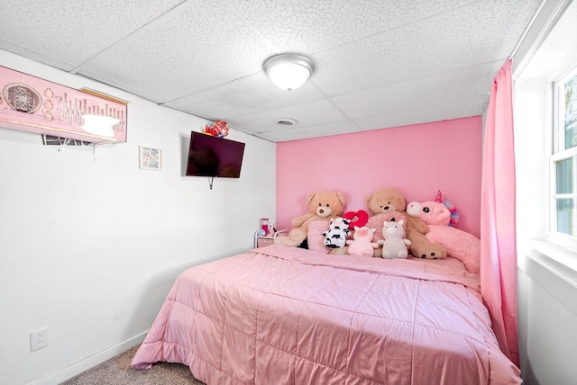 carpeted bedroom featuring a paneled ceiling, visible vents, and baseboards