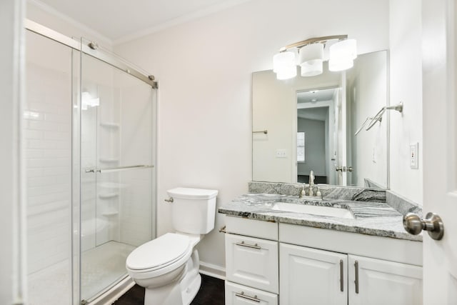 bathroom with a stall shower, baseboards, toilet, ornamental molding, and vanity