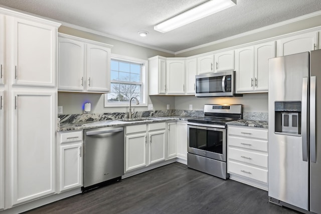 kitchen featuring stone counters, dark wood-style flooring, appliances with stainless steel finishes, white cabinets, and a sink