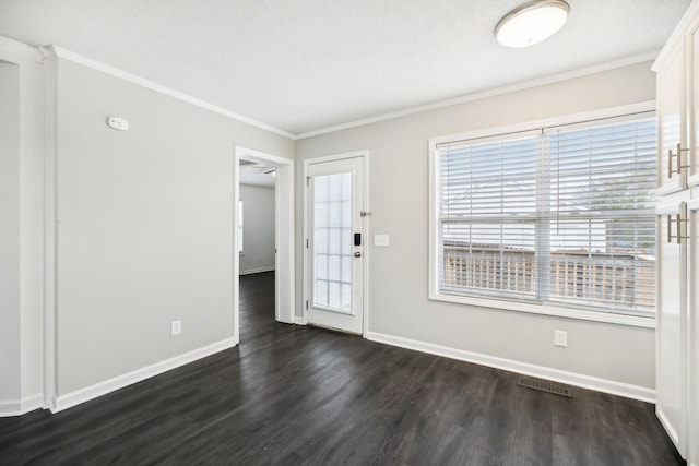 interior space with baseboards, visible vents, dark wood finished floors, and ornamental molding