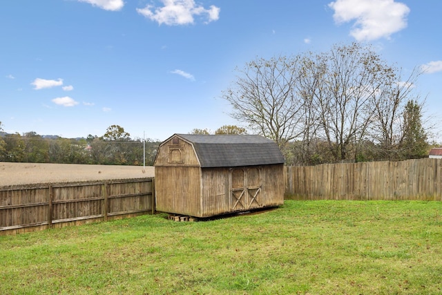 view of yard featuring a storage shed, fence, and an outdoor structure