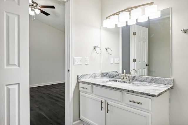 bathroom featuring ceiling fan, wood finished floors, vanity, and baseboards